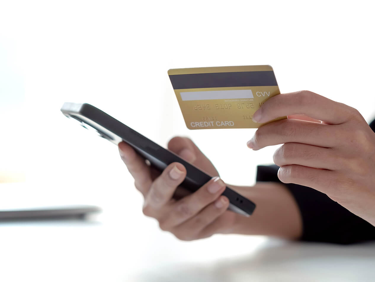 スマホとクレジットカードを持っている手の写真