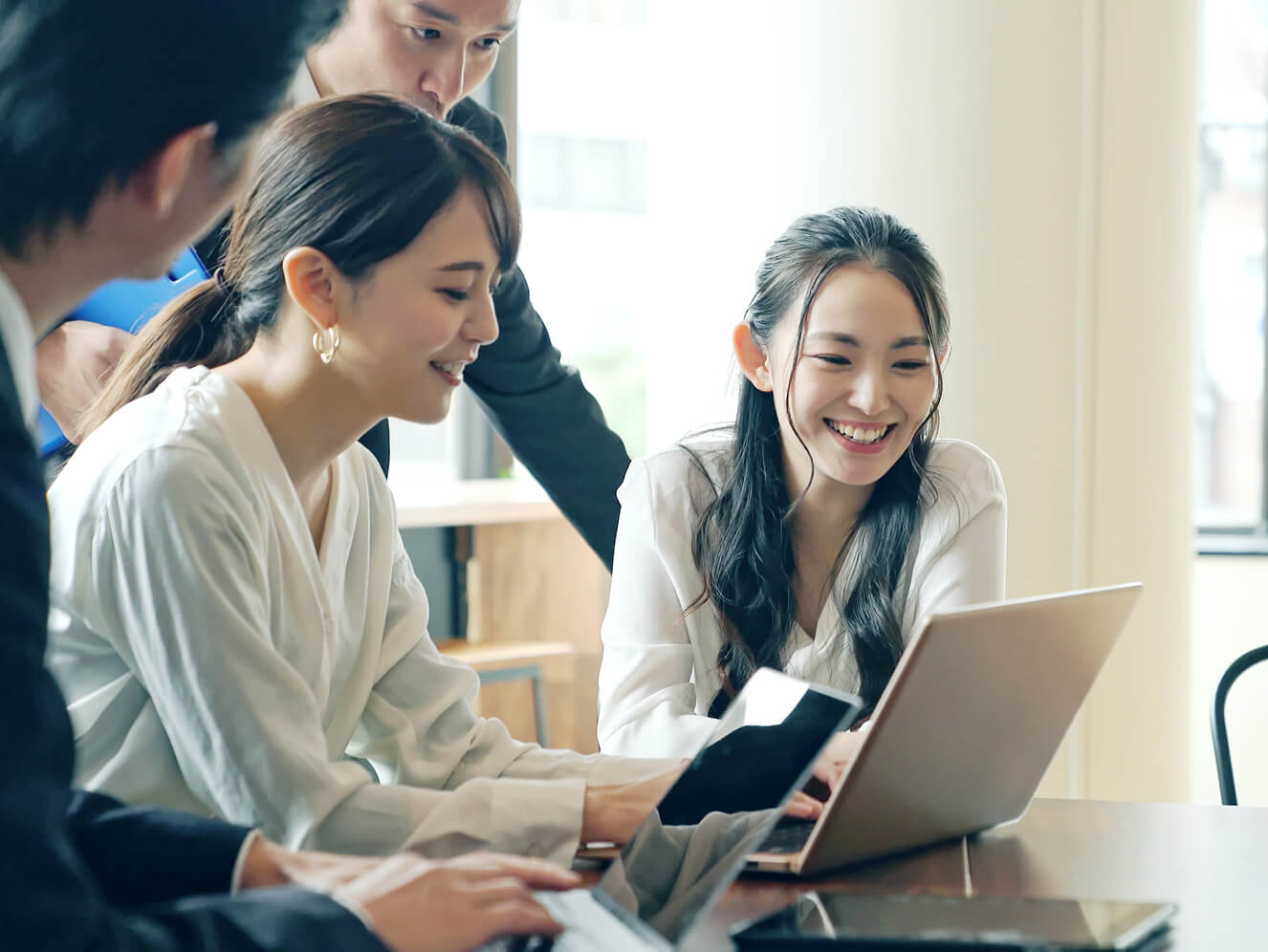 複数人でパソコンを囲み見ている写真